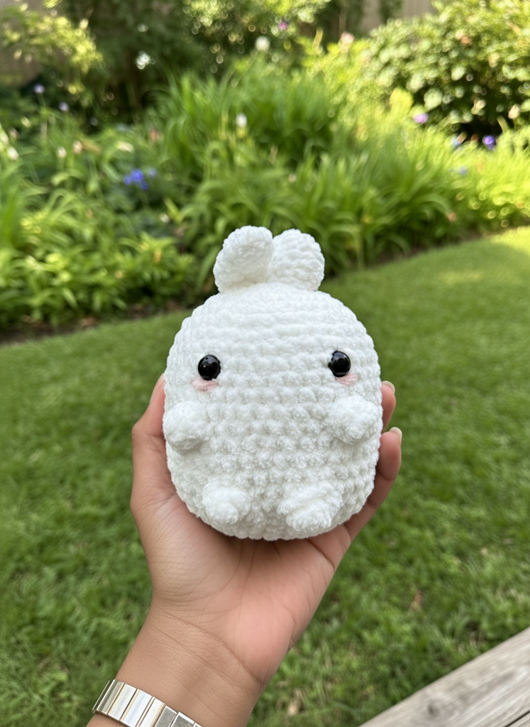 Handmade crochet Molang bunny plushie held in hand showing soft white chenille yarn texture and kawaii design